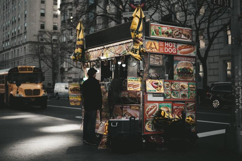 A Customer Ordering From a Hot Dog Labelled Food Truck